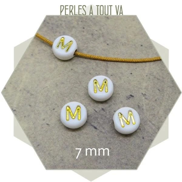 7g de perles lettre M, blanches et or (50 perles env.)