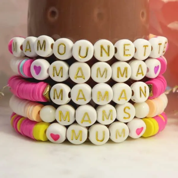 7g de perles lettre M, blanches et or (50 perles env.)